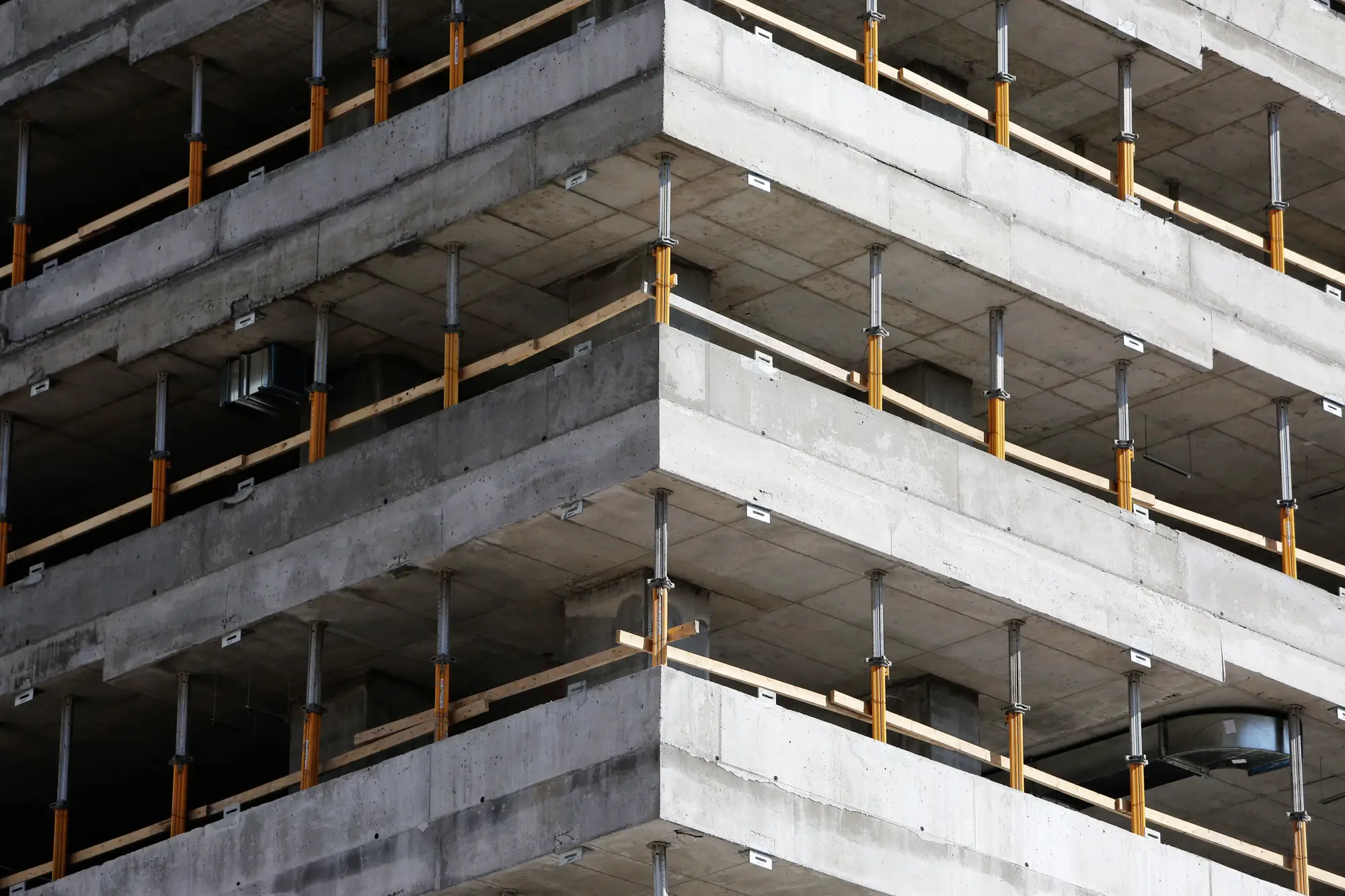 Open slab edges on a concrete frame, each floor lined with timber edge protection on props